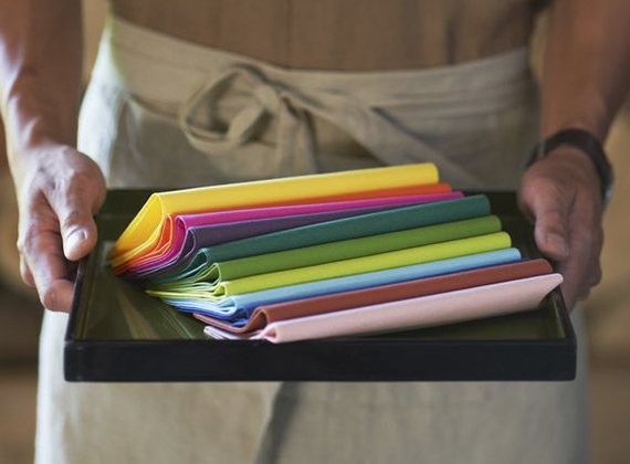 Waiter holding coloured premium napkins