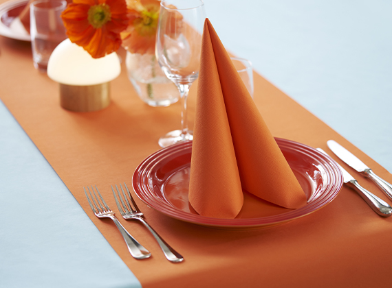 Bright orange formal table setting on neutral table