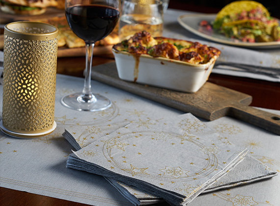 Stacked napkins on a restaurant table with served food in the background